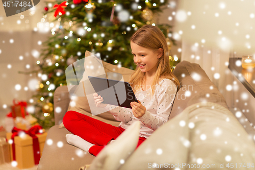 Image of smiling girl with tablet pc at christmas home