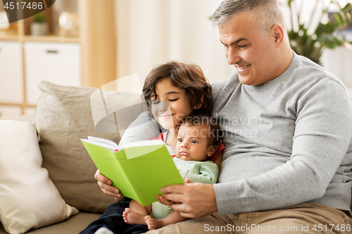 Image of happy father with sons reading book at home