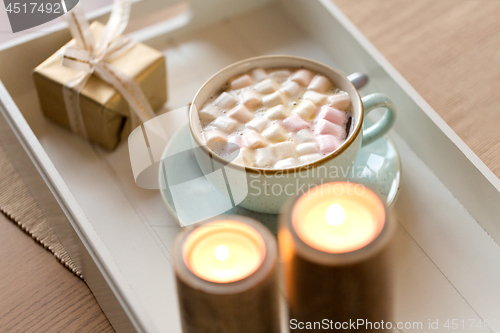 Image of hot chocolate, christmas gift and candles on table