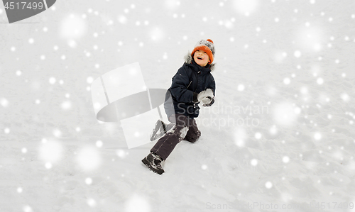Image of happy little boy playing with snow in winter