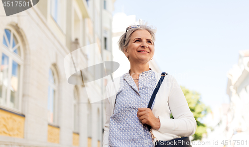 Image of happy senior woman on city street in summer