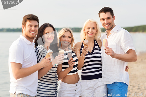 Image of happy friends eating ice cream on beach