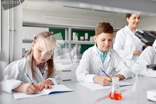 Image of teacher and students studying chemistry at school