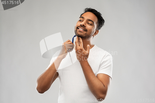 Image of indian man shaving beard with razor blade