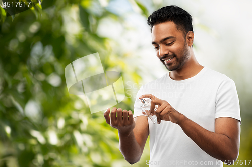 Image of indian man with perfume over natural background