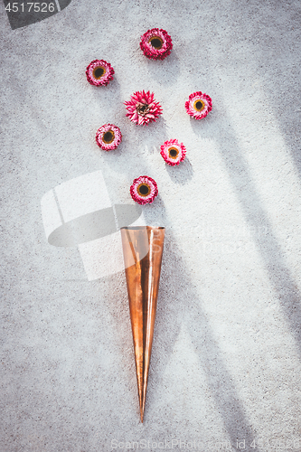 Image of Copper cone and strawflowers on concrete background