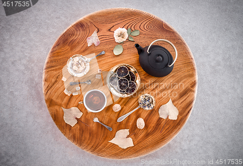 Image of Tea, flowers and sweets on round wooden table