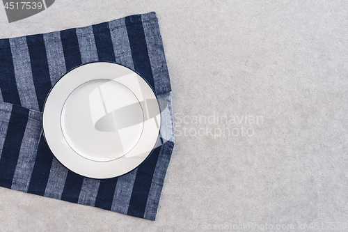 Image of White plate and striped tablecloth