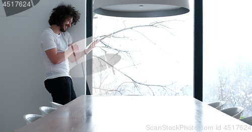 Image of young man using a tablet at home