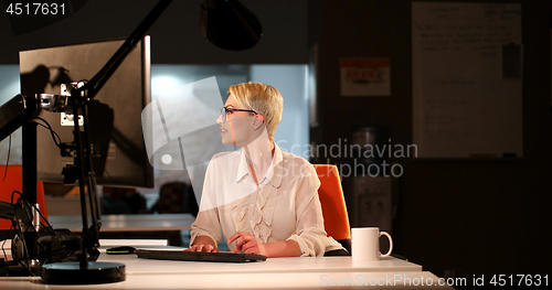 Image of woman working on computer in dark office