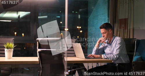 Image of man working on laptop in dark office