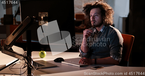 Image of man working on computer in dark office