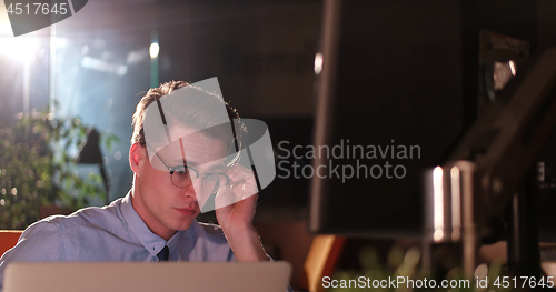 Image of man working on computer in dark office