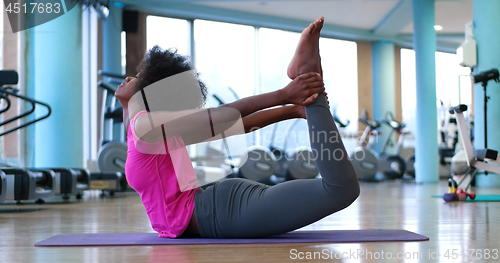 Image of back woman in a gym stretching and warming up