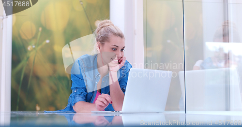 Image of young women using laptop computer on the floor