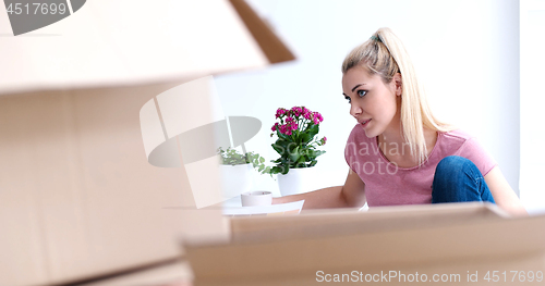 Image of woman with many cardboard boxes sitting on floor