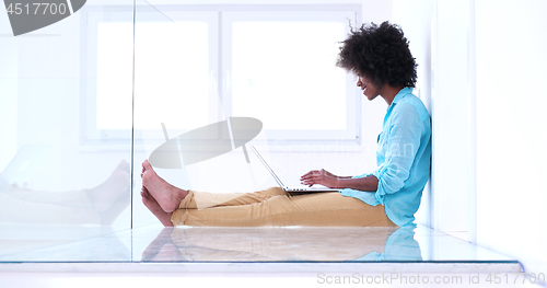 Image of black women using laptop computer on the floor