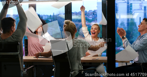 Image of multiethnic Group of young business people throwing documents