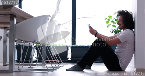 Image of young man using a tablet at home