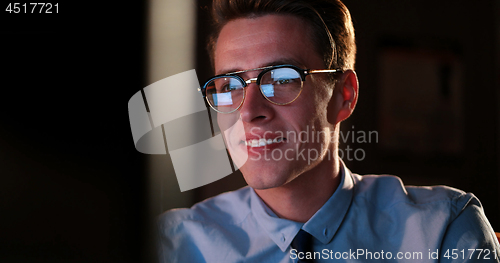 Image of man working on computer in dark office