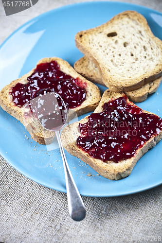 Image of Fresh toasted cereal bread slices with homemade wild berries jam