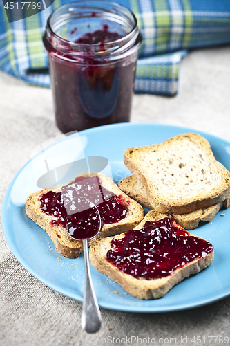 Image of Toasted cereal bread slices on blue ceramic plate and homemade w