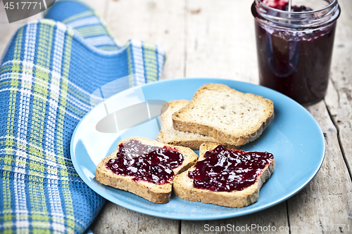 Image of Toasted cereal bread slices on blue ceramic plate and homemade w