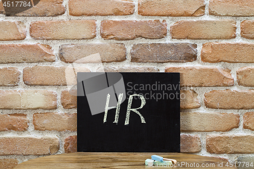 Image of Chalk board with the word HR drown by hand and chalks on wooden 