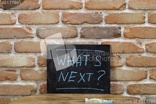 Image of Chalk board with the phrase WHAT'S NEXT? drown by hand and chalk