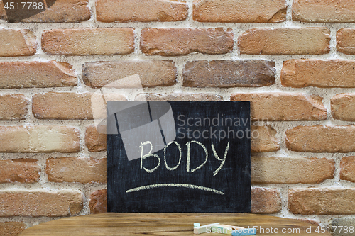 Image of Chalk board with the word BODY drown by hand and chalks on woode