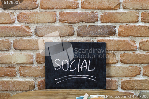 Image of Chalk board with the word SOCIAL drown by hand and chalks on woo