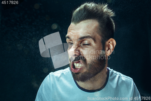 Image of Young handsome man with beard sneezing, studio portrait