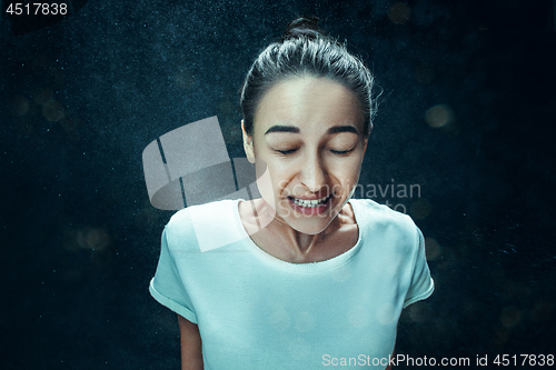 Image of Young woman sneezing, studio portrait