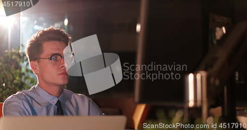 Image of man working on computer in dark office