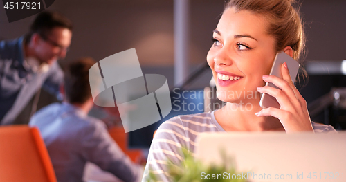 Image of woman using mobile phone in dark office