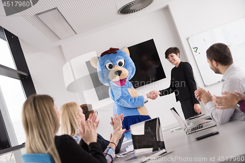 Image of boss dresed as bear having fun with business people in trendy of