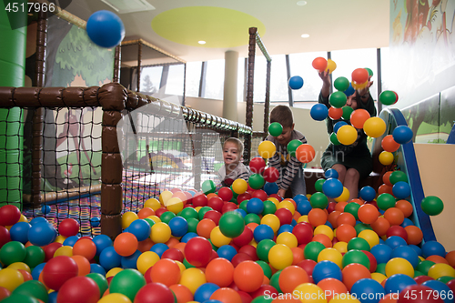 Image of Young mom with her kids in a children\'s playroom