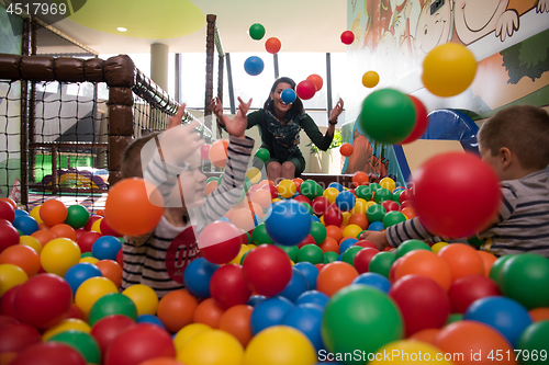 Image of Young mom with her kids in a children\'s playroom