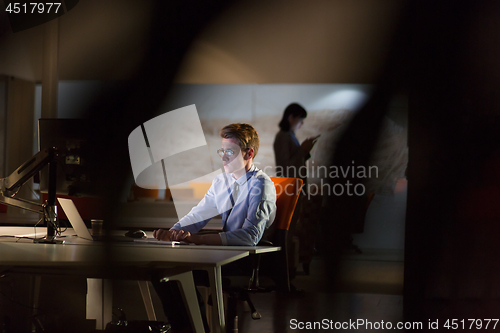 Image of man working on computer in dark office