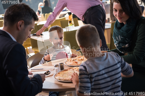 Image of Young parents enjoying lunch time with their children