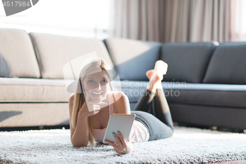 Image of young women using tablet computer on the floor