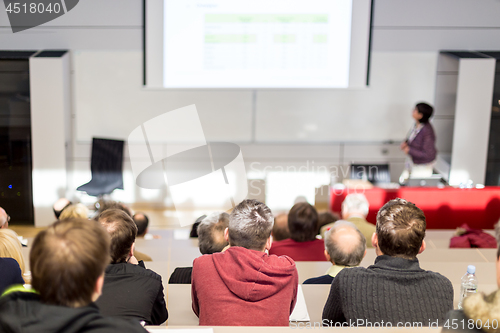 Image of Woman giving academic presentation in lecture hall at university.