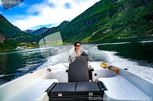 Image of Woman driving a motor boat. Geiranger fjord, Beautiful Nature No