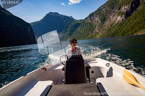 Image of Woman driving a motor boat. Geiranger fjord, Beautiful Nature No