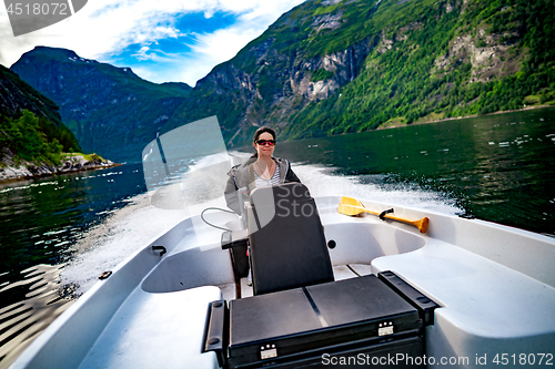 Image of Woman driving a motor boat. Geiranger fjord, Beautiful Nature No