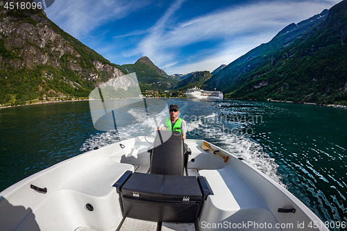 Image of Man driving a motor boat. Geiranger fjord, Beautiful Nature Norw