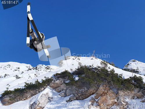 Image of Extreme skier jumping from mountain blue sky in backgraund