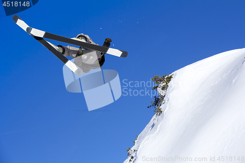 Image of Extreme skier jumping from mountain blue sky in backgraund