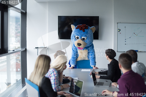 Image of boss dresed as bear having fun with business people in trendy of