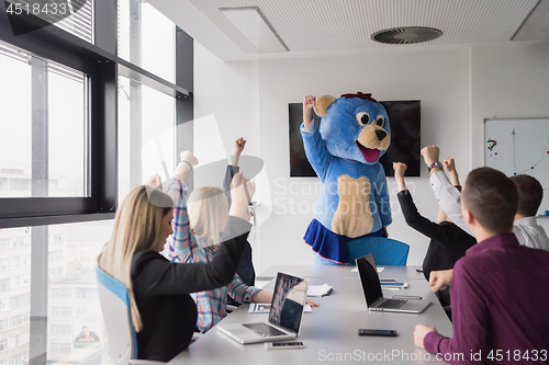 Image of boss dresed as bear having fun with business people in trendy of